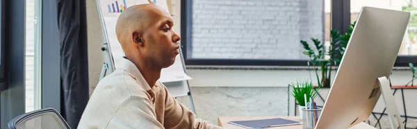 stock image inclusion, african american man with myasthenia gravis at work, bold and dark skinned office worker using computer, looking at monitor, graphs and flipchart on background, banner 