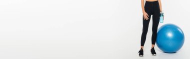 Kırpılmış, spor ayakkabılı kadın elinde spor şişesi, beyaz arka planda spor topu, afiş