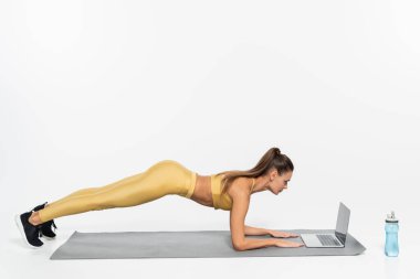 e-sports, woman doing plank on fitness mat, white background, physical activity concept, laptop  clipart