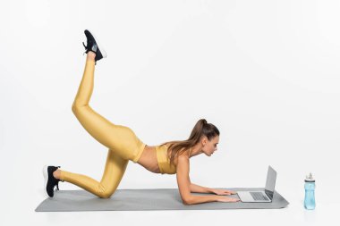 E-spor, aktif spor yapan kadın beyaz arka planda dizüstü bilgisayar eğitimi alıyor, fiziksel aktivite 