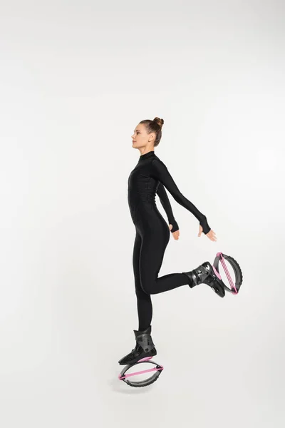stock image workout and strength, woman in kangoo jumping shoes exercising on white background, jumping boots 