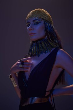 Mısırlı güzel bir kadının portresi. Mavi ışıkla kahverengi kameraya bakıyor ve poz veriyor.