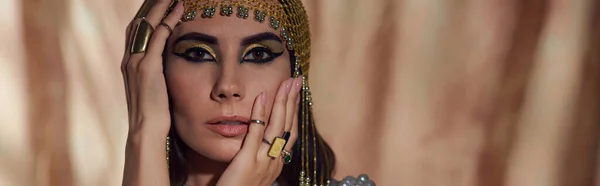 Mujer Morena Con Maquillaje Egipcio Tocado Tocando Cara Sobre Fondo —  Fotos de Stock