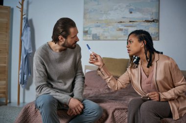angry african american woman arguing with man, showing pregnancy test, blame, abortion concept clipart