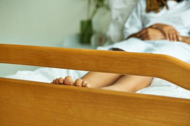 cropped view of barefoot african american woman, toes, bare feel, hospital private ward, lying down clipart