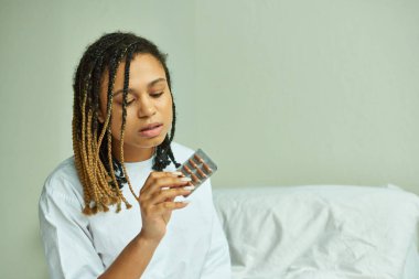 Afro-Amerikan kadın hastane önlüklü, elinde haplar, özel koğuş, düşük, klinikteki hasta