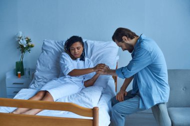 Düşük, depresyondaki Afrikalı Amerikalı kadın kocasının elini tutuyor, keder, hastane koğuşu.