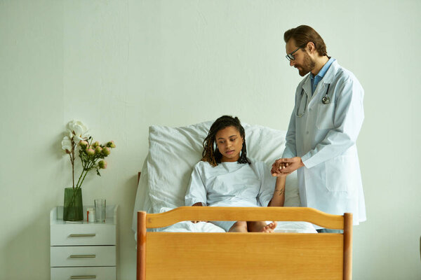 бородатый доктор в очках, держащий за руку африканскую американку в больничном халате, частное отделение