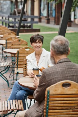 Neşeli kadın ve erkek, açık kafede kahve içiyor, teras, yaşlı çift, yaz, şehir.