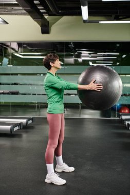 Spor salonunda spor yapan yaşlı bir kadın, aktif son sınıf, spor ve spor, yan görüş.