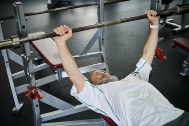 güçlü sakallı yaşlı bir adam spor salonunda halterle çalışıyor, aktif son sınıf, atlet, güçlü.
