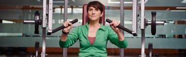 strong and motivated elderly woman exercising in gym, mature fitness, energy, active senior, banner clipart