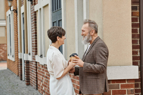 счастливая пожилая пара, кофе на вынос, здание, пожилой мужчина и женщина, смех, глядя друг на друга