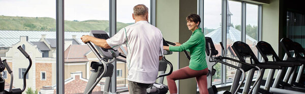 active seniors, cheerful woman looking at elderly man, exercising together, senior couple, banner