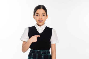 surprised schoolgirl pointing with finger at herself and looking at camera isolated on white, girl clipart