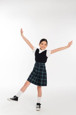 excited schoolgirl standing with outstretched hands isolated on white, full length, happiness clipart