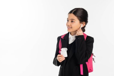 Üniformalı gülümseyen kız elinde kablosuz kulaklıkla beyaz, pozitif.