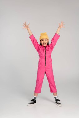 Bereli ve pembe elbiseli mutlu kız ellerini griye uzatmış duruyor, eğlen, stil yap
