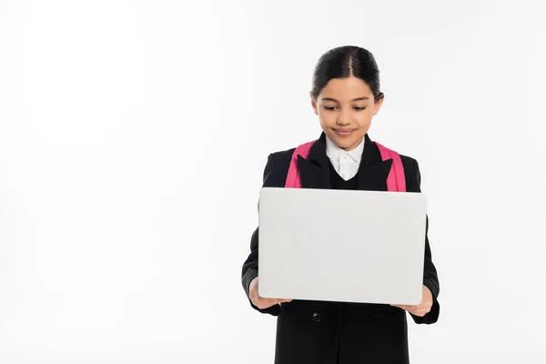 stock image smiling schoolgirl using laptop isolated on white, e-study, student in uniform isolated on white