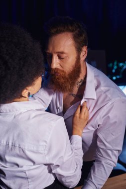 Afro-Amerikan kadın, gece ofiste sakallı, dövmeli işadamını baştan çıkarıyor, iş yerinde flört ediyor.