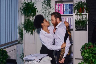 Fotokopi makinesinin yanında sakallı iş adamını soyan ateşli Afrikalı Amerikalı kadın, gece ofisinde aşk.