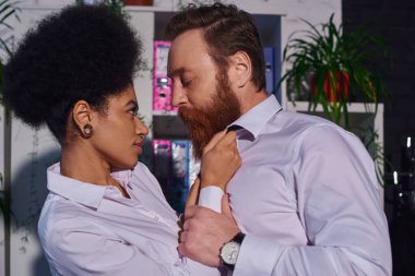 Afro-Amerikan kadınlarının gece ofisinde sakallı işadamıyla flört etmesinin yan görünüşü