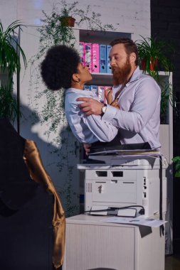 Ofisteki gizli aşk, sakallı iş adamı ve gece fotokopi makinesinin yanında sarılan Afrikalı Amerikalı kadın.