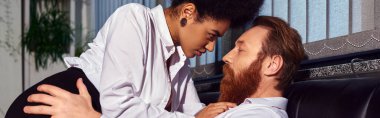 Seksi Afrikalı Amerikalı iş kadını gece ofisindeki koltukta sakallı adamı baştan çıkarıyor.