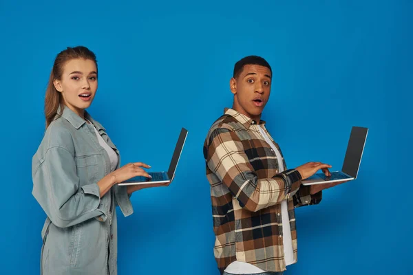 Amazed Interracial Freelancers Using Laptops Blue Backdrop Diverse Cultures Man — Stock Photo, Image