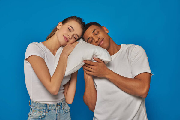 joyful interracial couple sleeping together on pillow, african american man and caucasian woman