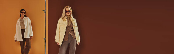 осенняя мода, мультиэтнические женщины в солнцезащитных очках и верхней одежде позируют на красочном фоне, баннер
