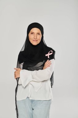 Göğüs kanseri pembe kurdeleli tesettürlü gülümseyen kadın griye izole edilmiş farkındalık