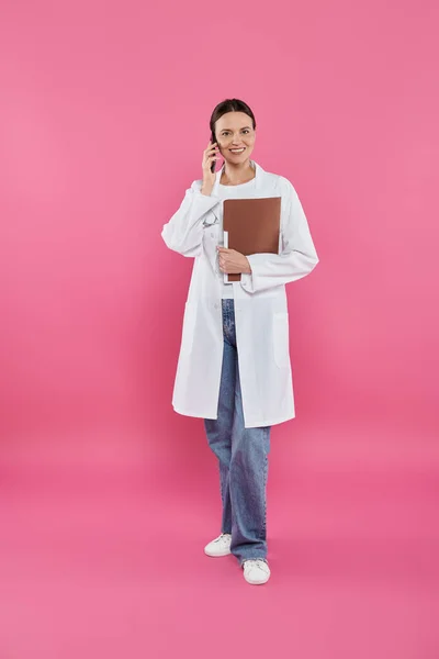 stock image breast cancer awareness, doctor, happy oncologist talking on smartphone, online consultation