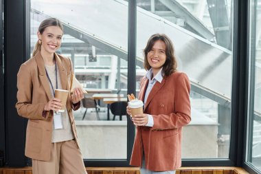 elegant colleagues in business casual attires smiling and enjoying coffee and sandwiches, coworking clipart
