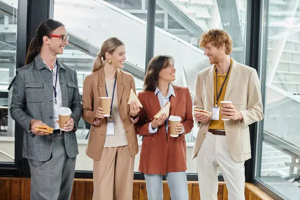 stock image hard working young team enjoying their lunch posing with window on background, coworking concept