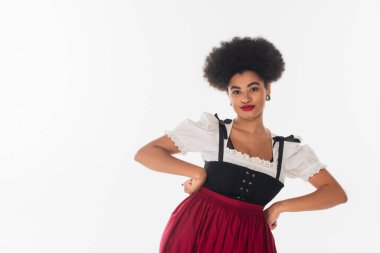 Kendine güvenen Afro-Amerikan Ekim Festivali garsonu geleneksel giyinmiş elleri beyaz kalçalarında