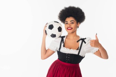 Neşeli Afro-Amerikan Ekim Festivali garsonu Dirndl 'de futbol topu tutuyor ve beyazlar gibi oynuyor.