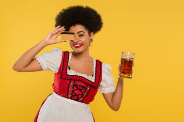 Neşeli Afro-Amerikan Oktoberfest bira kupası ile yüzünü gizleyen sarı kart ile
