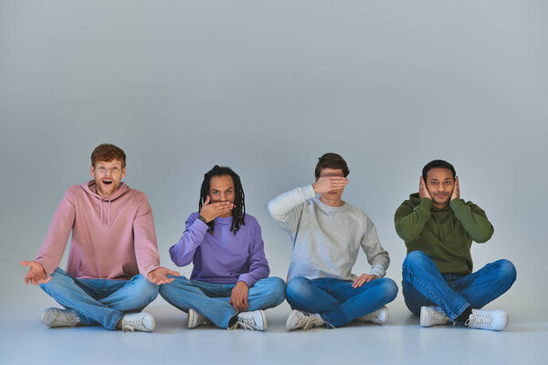 four young men sitting with crossed legs and gesturing, like four wise monkeys concept, diversity
