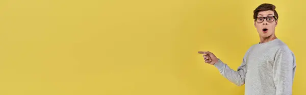 Zdumiewający Radosny Mężczyzna Luźnym Stroju Wskazującym Palcem Prawej Strony Żółte — Zdjęcie stockowe