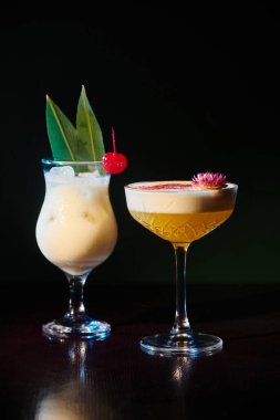 Tropikal egzotik pina colada ve daiquiri ile siyah arka planda taze süsleme, konsept