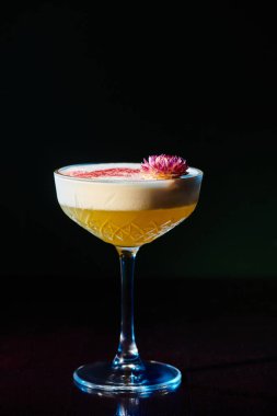 delicious frothy daiquiri with pink fresh flower on foam on black backdrop, concept clipart