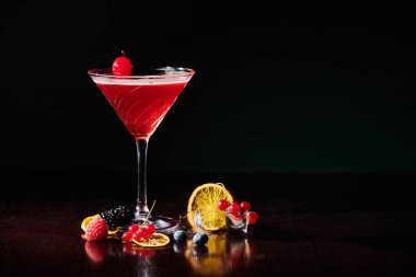 freshening cosmopolitan garnished with cocktail cherry on black background, concept clipart