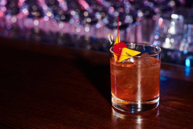 Bar tezgahında kirazla süslenmiş nefis bir susuzluk negroni söndürüyor.