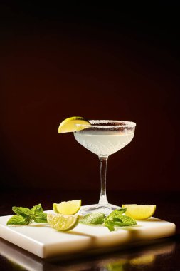 Buzlu soğuk bir bardak sofistike margarita. Siyah arka planda limon dilimi, konsept.