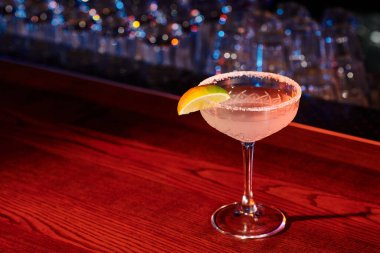 Lezzetli margaritayla dolu ferahlatıcı bardaklar siyah arka planda limonla süslenmiş, konsept