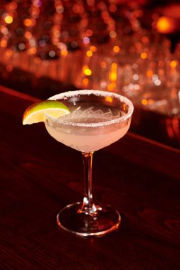 Bar tezgahında limon dilimiyle süslenmiş buzlu soğuk margarita içeceği.