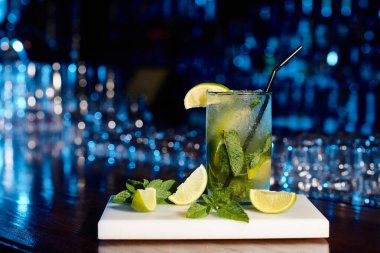 Buzlu, sofistike mojito kokteyli. Nane yaprakları ve bar zemininde limon, konsept.