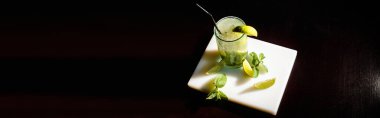 Buzlu mojito kokteylinin üst görüntüsü ve siyah arkaplan, konsept ve afiş üzerine nane şekeri.