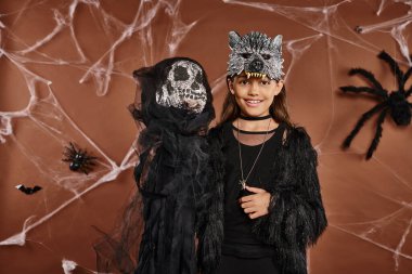 close up cheerful preadolescent girl in wolf mask showing Halloween toy, Halloween concept clipart